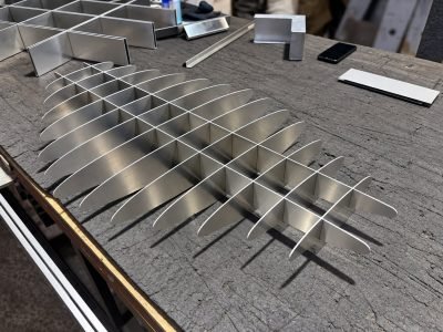 Stainless steel fin elements laid out for a sculptural ceiling