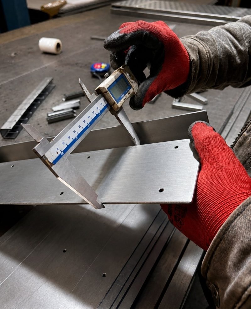 Checking a folded stainless steel part with a vernier caliper