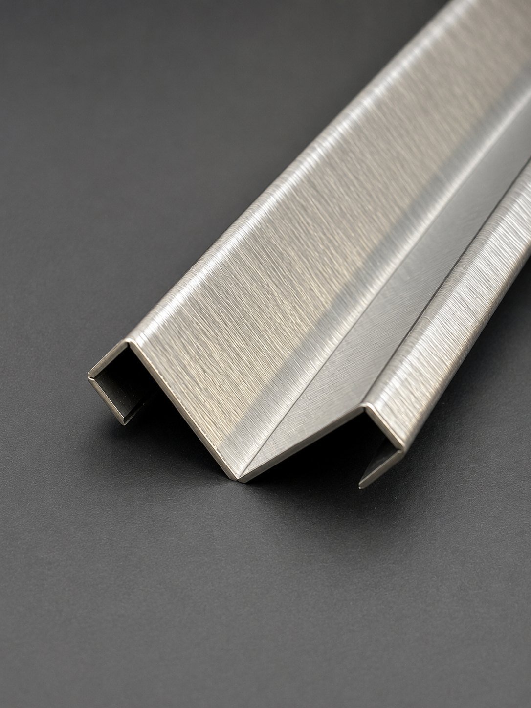 Stainless steel corner guard profile with a folded return edge, brushed finish