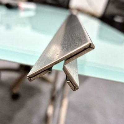 Custom T profile in brushed stainless steel on a glass surface