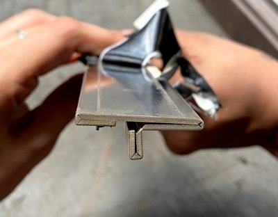 Custom T profile sample held in hand during fabrication