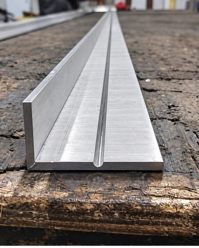 Custom U channel with a centre rib, brushed stainless steel, on the workshop bench