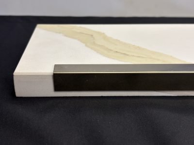 Dark bronze L profile fitted to the edge of a stone slab — L Profile · Architectural Profiles