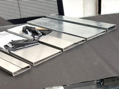 Rectangular stainless steel pipe profiles folded from sheet, laid out on a table