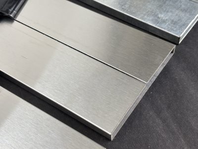 Rectangular stainless steel box sections with a hairline finish, close view