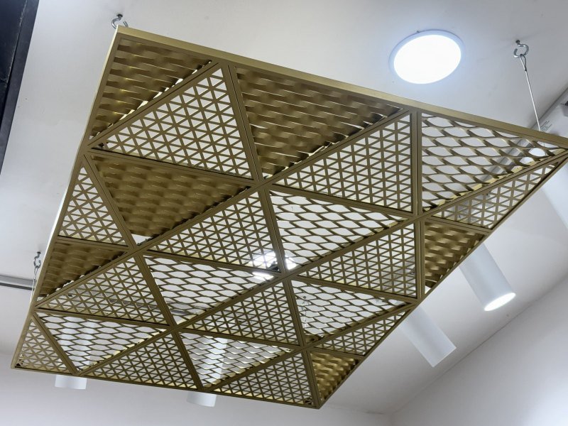 Brass-finish triangular grid ceiling in the showroom
