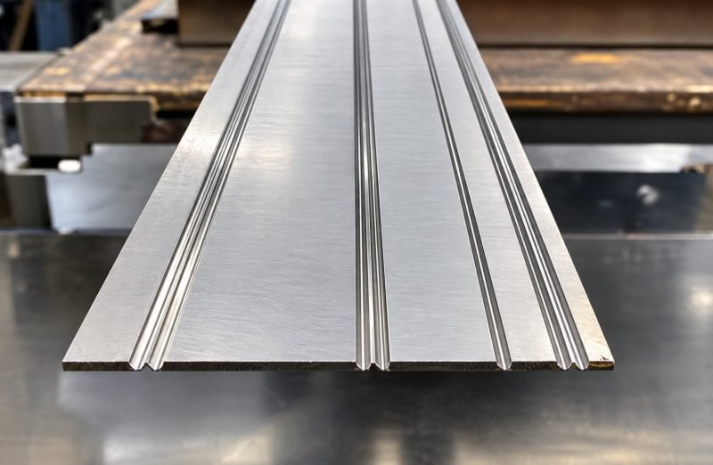 Stainless steel sheet with parallel V-grooves before folding