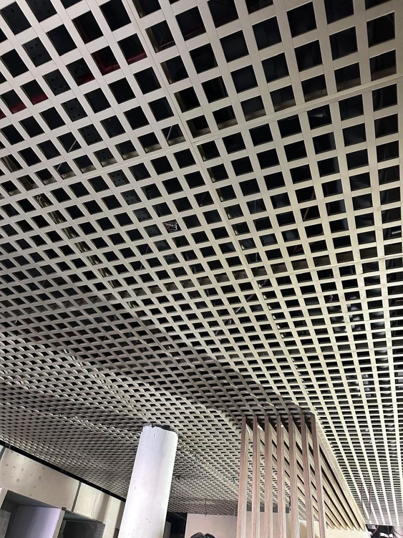 Open-cell metal grid ceiling installed across an office floor