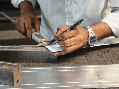 Marking a stainless steel profile on the workbench before cutting — Prototype Development · Custom Fabrication