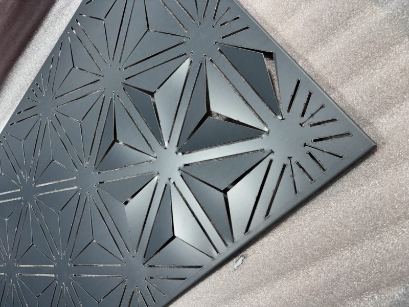 Laser-cut star-pattern façade panel in a dark grey finish