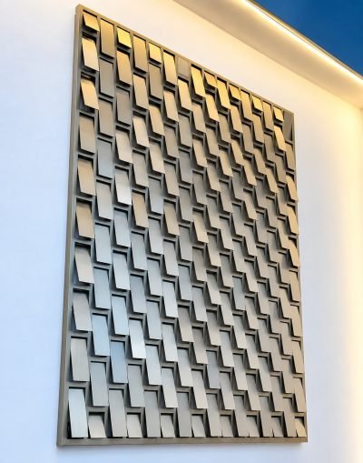 Kinetic façade panel with angled tiles, mounted on a wall