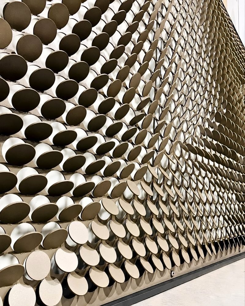 Metal coin façade panel with raised discs in stainless steel, close view