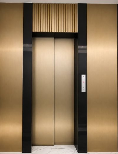 Lift entrance clad in champagne gold PVD with black frame