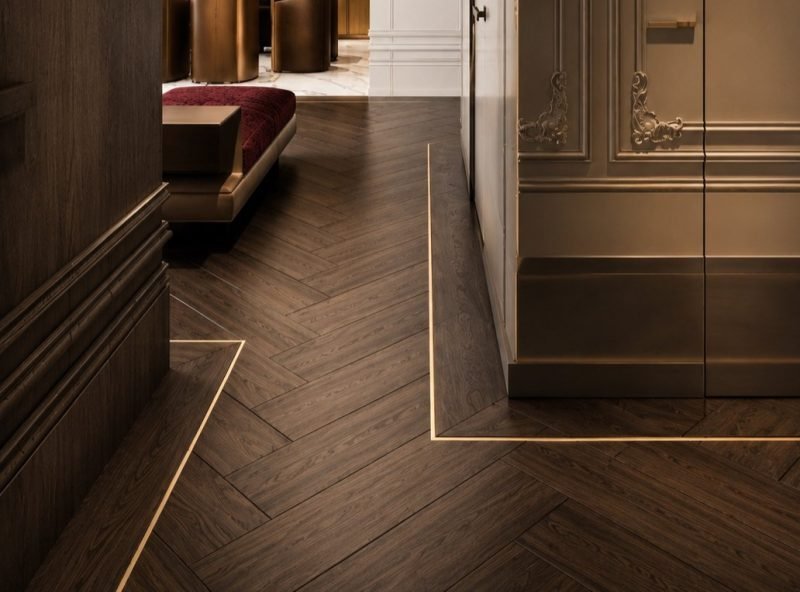 Brass inlay strips set into a herringbone wooden floor