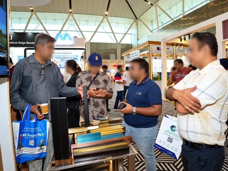 Visitors discussing coloured profile samples at the stand
