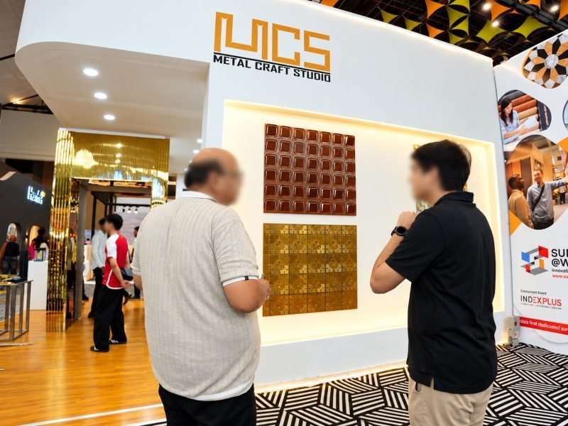 Visitors studying copper and gold wall panel samples