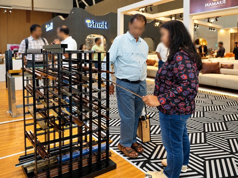 Visitors looking at a metal screen sample at the stand