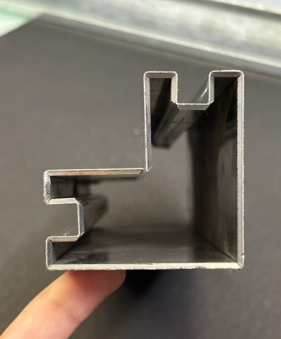 Corner glass housing profile held in hand, end view — Glass Housing Profiles · Glass Systems