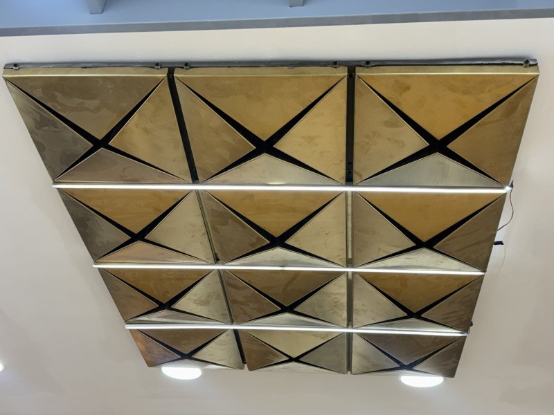 A faceted metal ceiling, lit from below