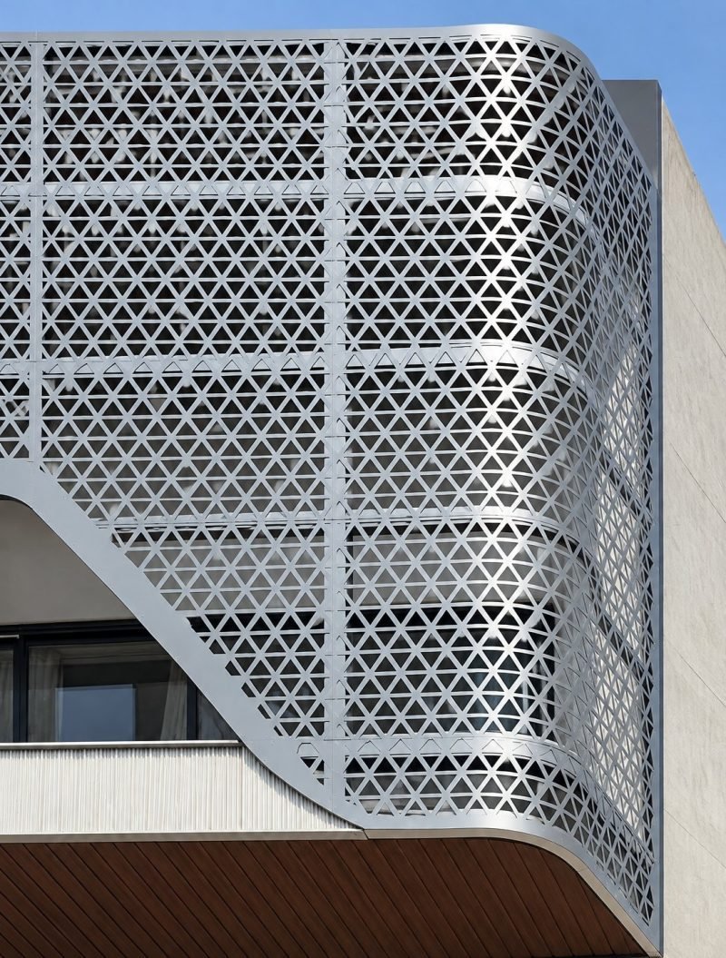 Perforated stainless steel façade screen with a triangular pattern, exterior