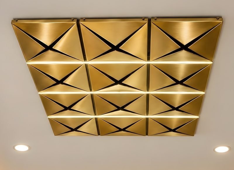 Designer ceiling panels in brass finish with triangular folds