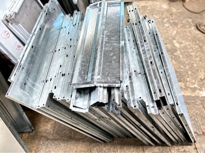 Stack of galvanised ceiling panel sections at the workshop — Ceiling Panels · Metal Ceilings