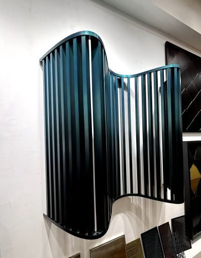 Parametric wall panel with curved fins in teal, front view