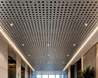 Perforated metal ceiling panels along a lobby corridor