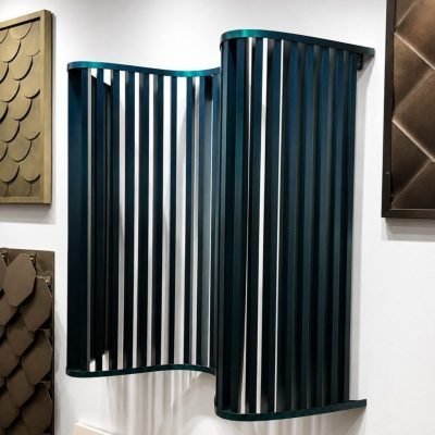 Wave-shaped metal fin panel in teal on the showroom wall