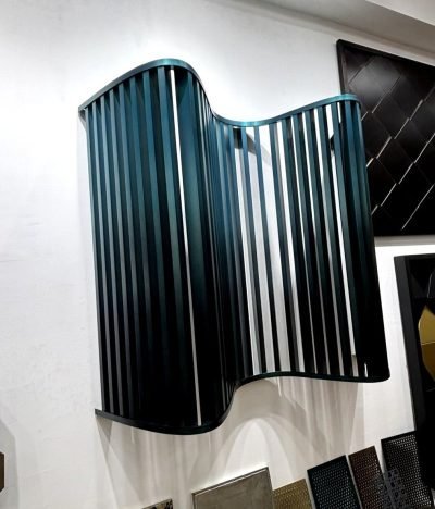 Wave-shaped metal fin panel in teal, side view