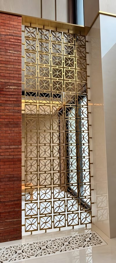 Decorative space divider with a geometric pattern in brass, corridor