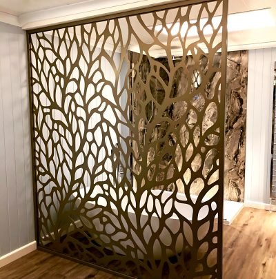 Laser-cut leaf-pattern metal room divider, installed
