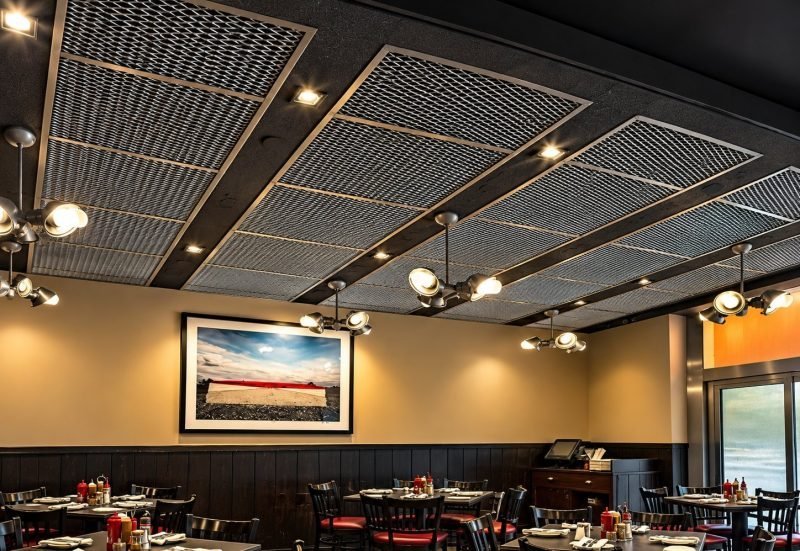 Restaurant with a suspended expanded metal mesh ceiling in framed panels